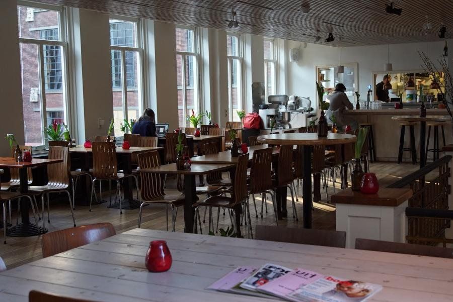 De lichte bovenverdieping met lange tafels